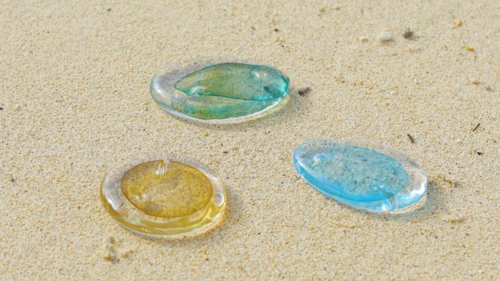 砂浜に並べられた琉球ガラスの作品