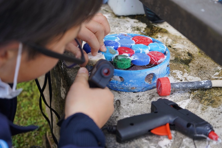 集めた漂着ゴミで作品を作る子供