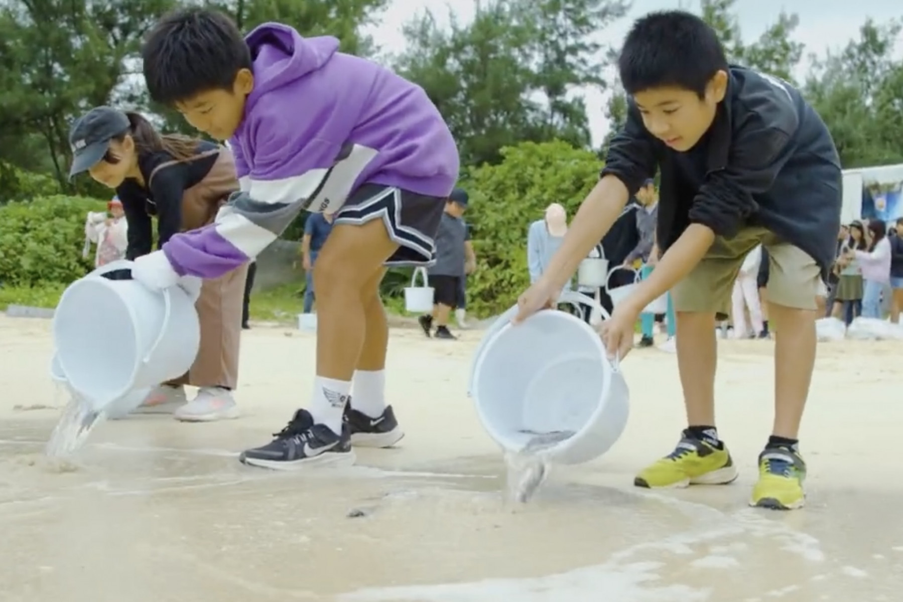 今帰仁 稚魚を放流する子供達
