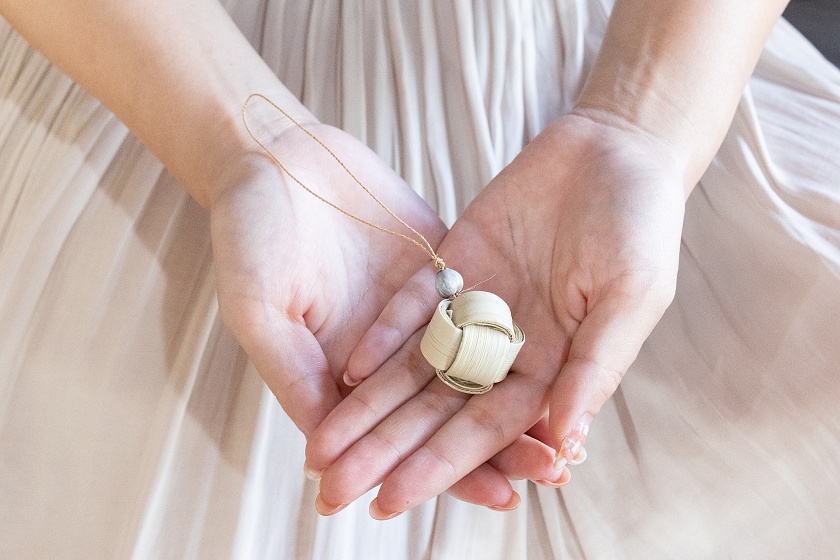 マース玉お守りを手にする女性