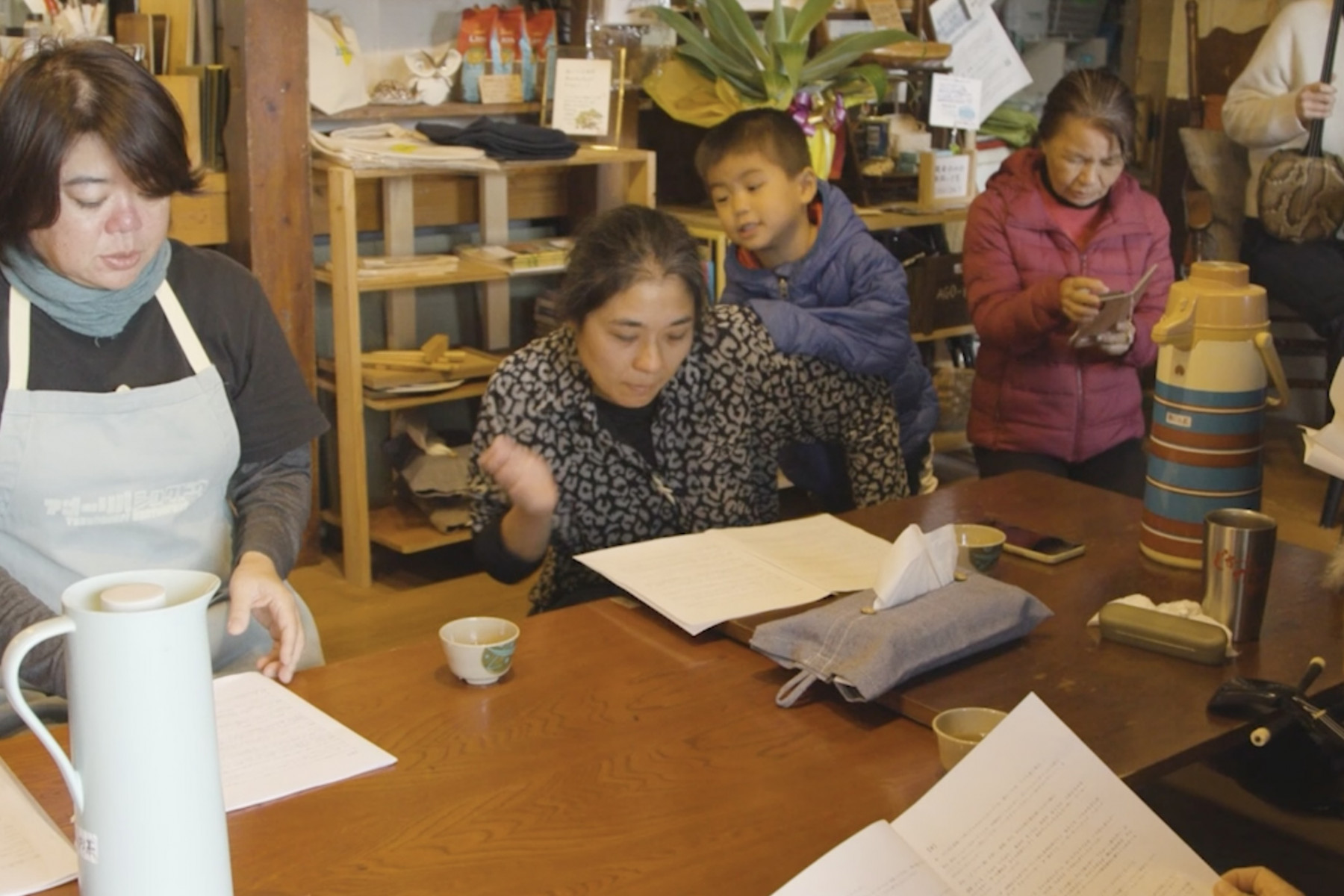 テーブルの前で芝居の練習をする人たち