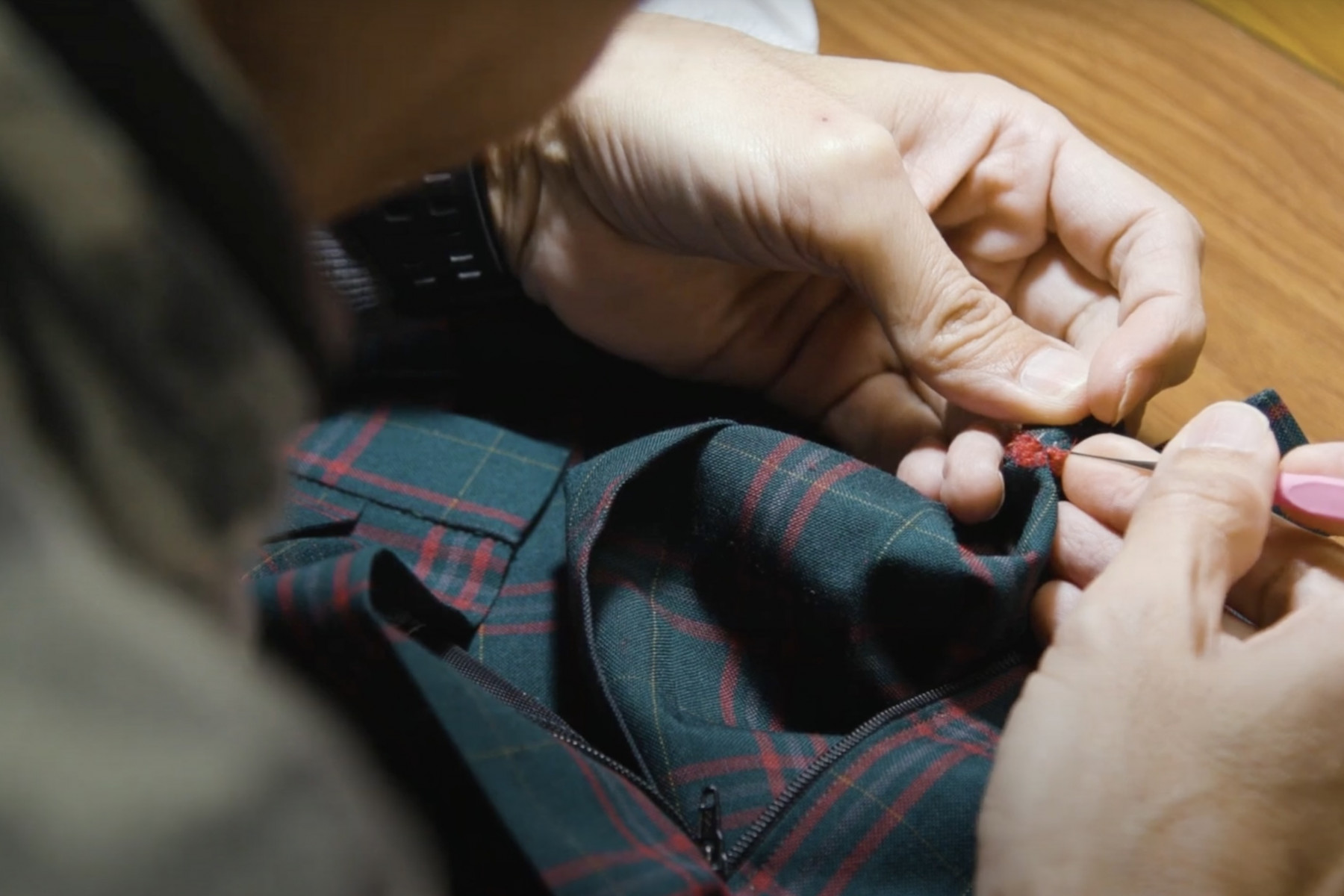 ネーム外しの作業をする人の手