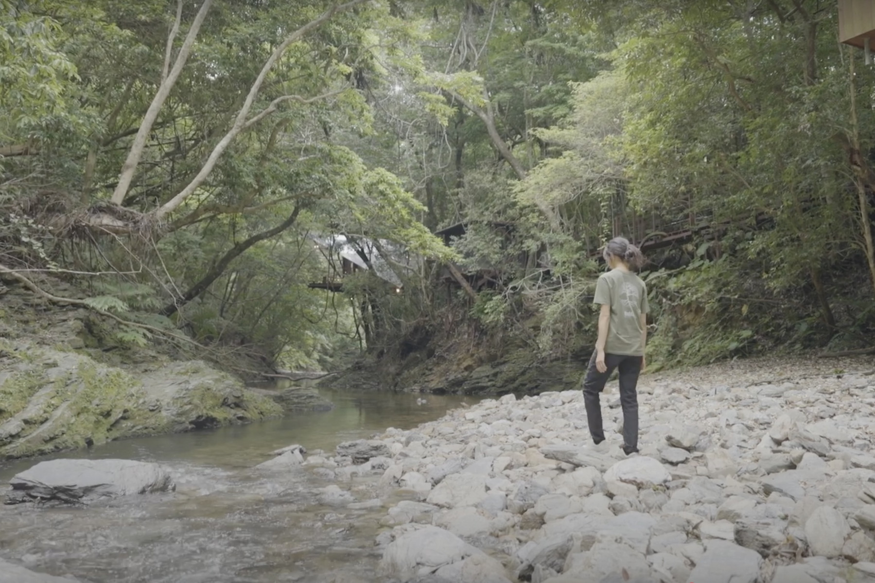 川のそばを歩く女性