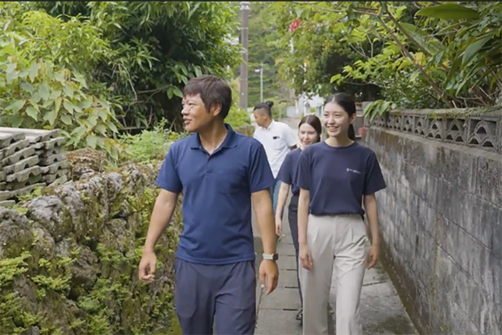 集落を散策する「ホット総研」のメンバー