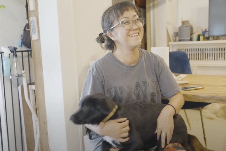 前山田さんの膝の上で嬉しそうな黒い犬トール