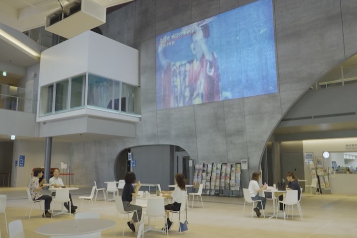 なはーとの館内で休息する人々