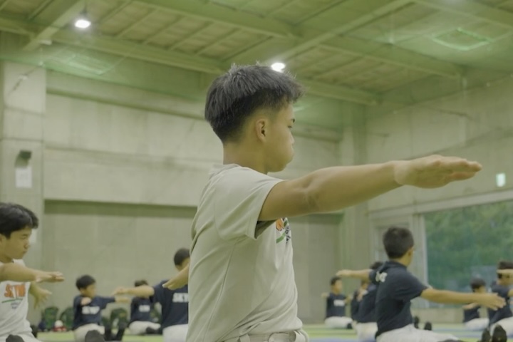 ベースボールピラティスを行う子ども