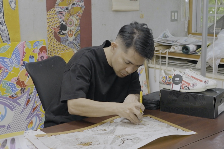 自身の作品に囲まれた工房で静かに型彫りをする知花幸修さん