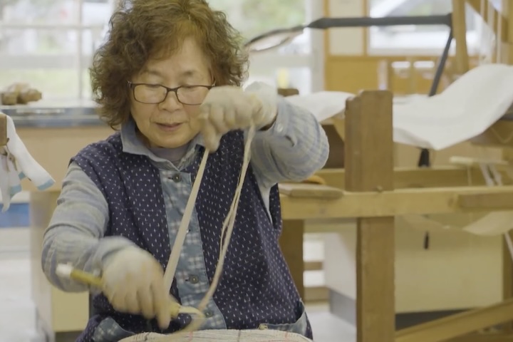 苧引き作業。エービと呼ばれる竹鋏で原皮をしごいて、不純物を取り除きます。