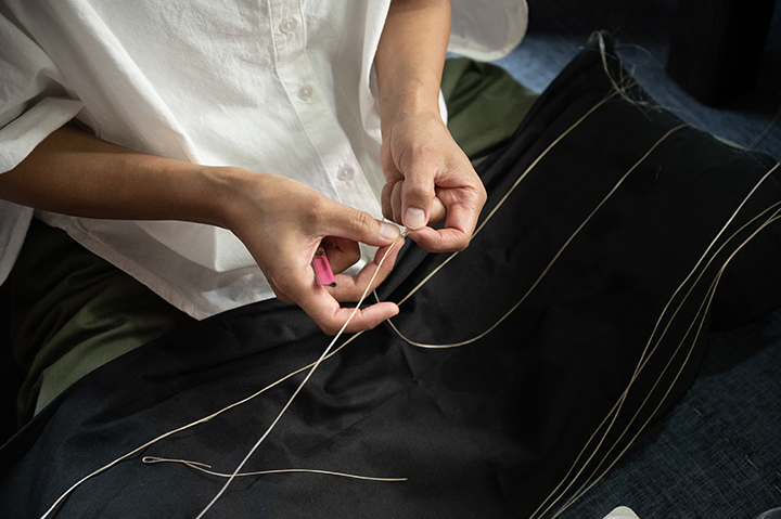 芭蕉の繊維を繋ぎ合わせて糸を作る作業「苧績み（うーうみ）」